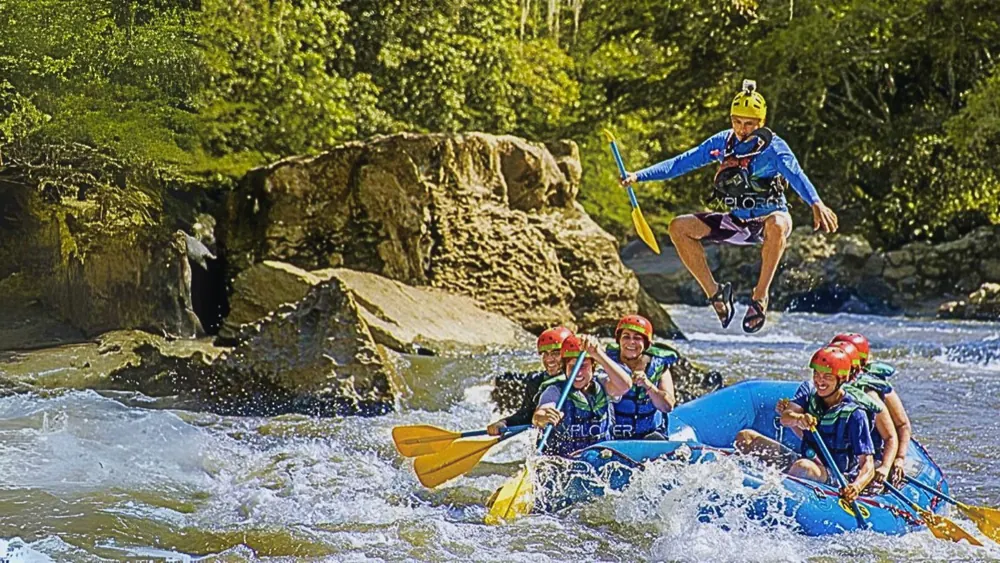 Balsa de rafting bajando el río Fonce con un guía saltando al agua