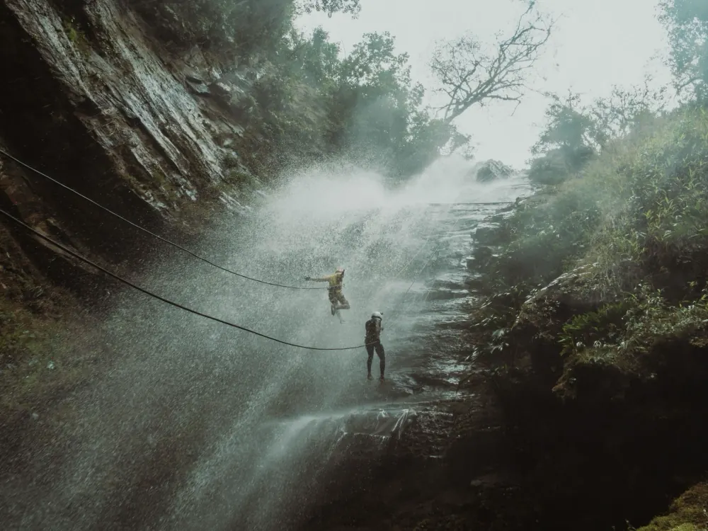 Persona descolgándose por la cascada de Juan Curí entre la neblina