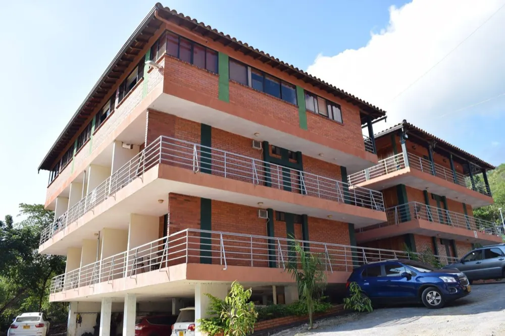 Fachada principal del Hotel Campestre Cacique Yariguí: bloque de tres pisos en ladrillo con balcones