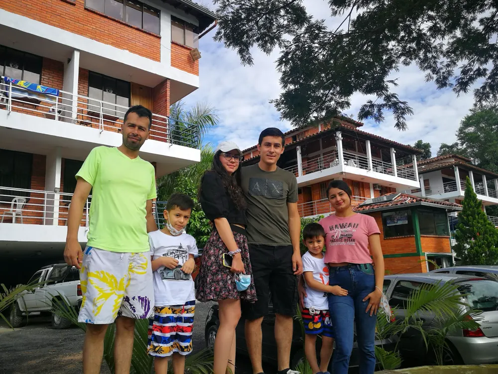 Familia de huéspedes posando frente al hotel