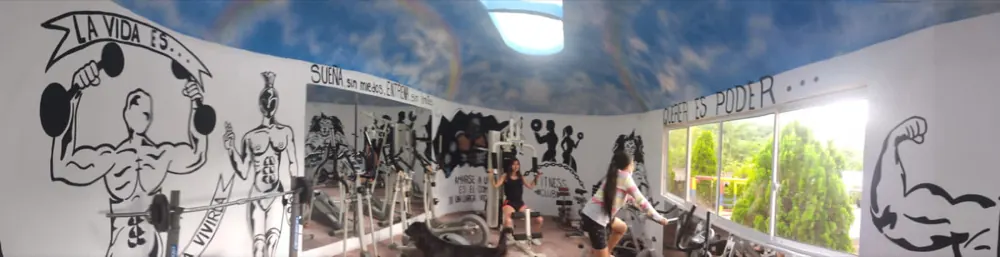 Gimnasio del hotel con murales pintados en las paredes