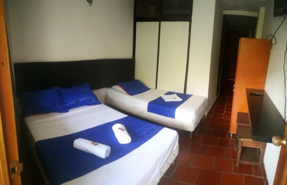 Habitación del hotel con cuatro camas sencillas
