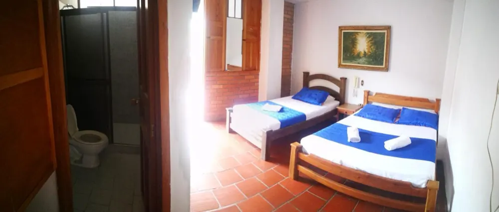 Habitación triple del hotel con el baño a la vista