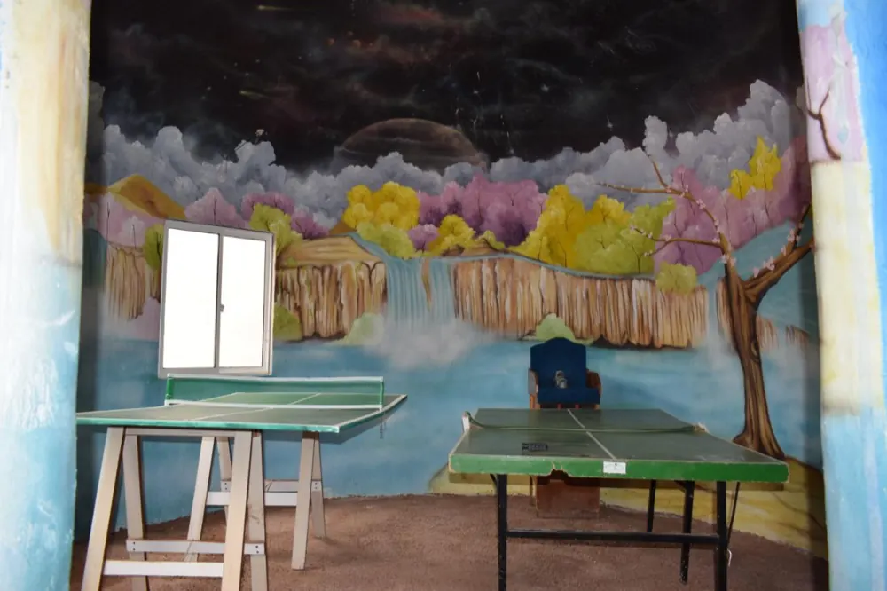 Mesa de ping pong del hotel con un mural pintado detrás