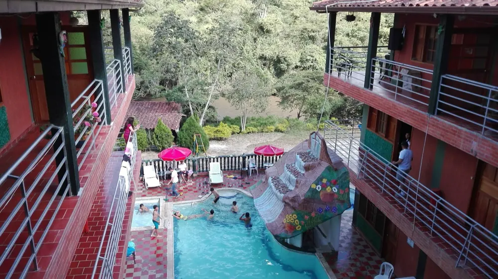 Piscina con tobogán al atardecer entre los bloques del hotel
