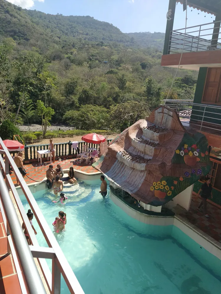 Piscina del hotel con tobogán y vista abierta a la montaña