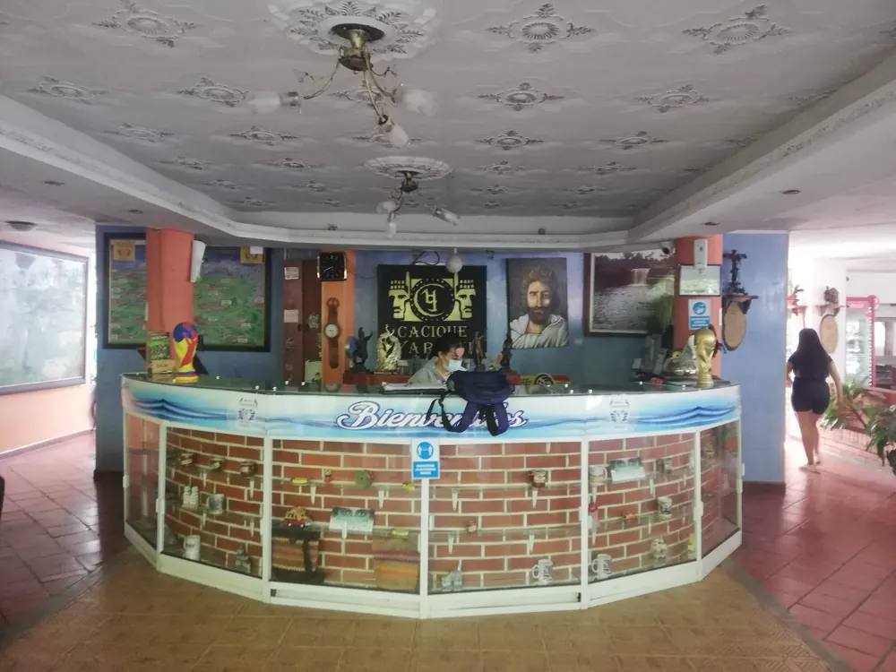 Recepción del hotel con mostrador en ladrillo y mural marino