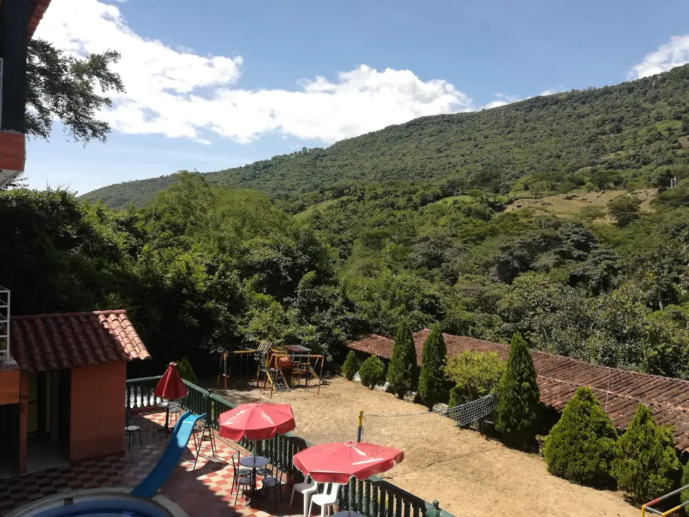 Vista desde una terraza del hotel hacia la montaña y las sombrillas rojas
